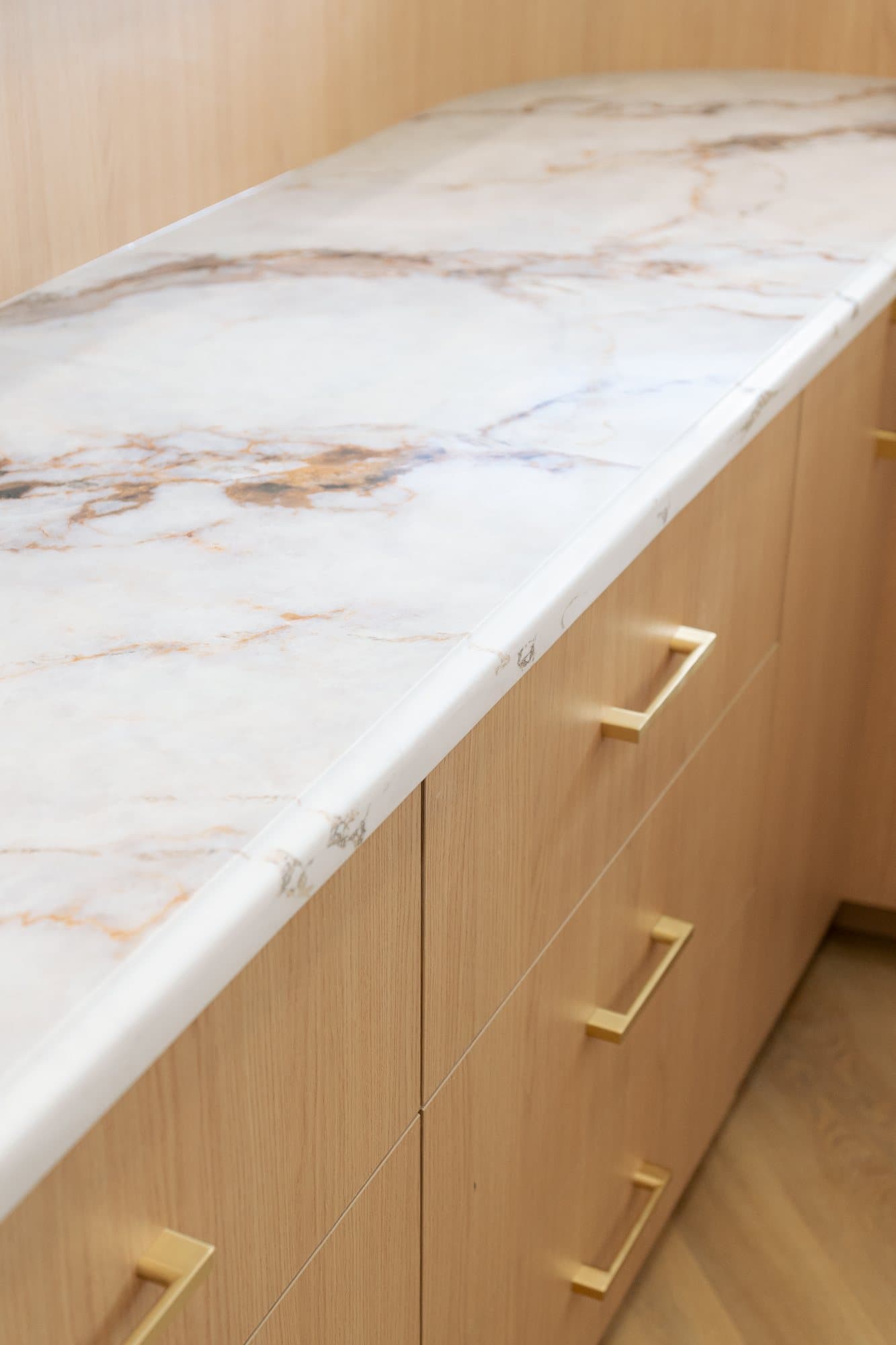Rust and gold veining in a marble counter above brass pulls