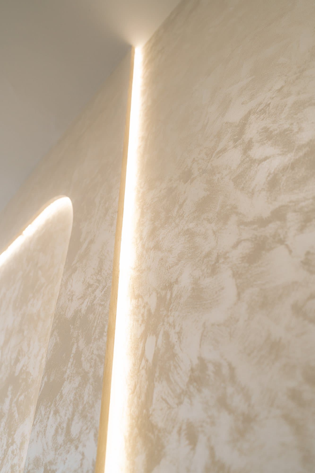 Detail of a warm light slot cut into a polished plaster wall
