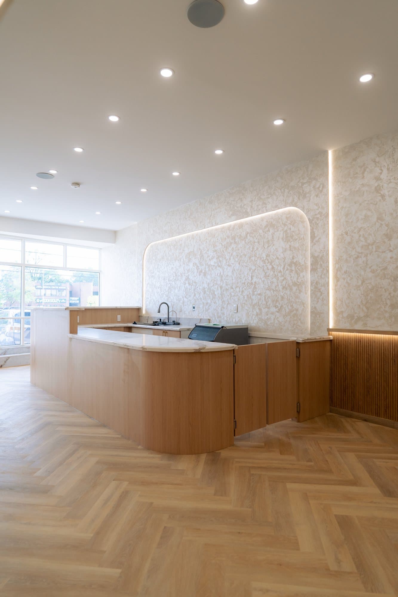 Finished cafe interior with a curved oak service counter and herringbone floor