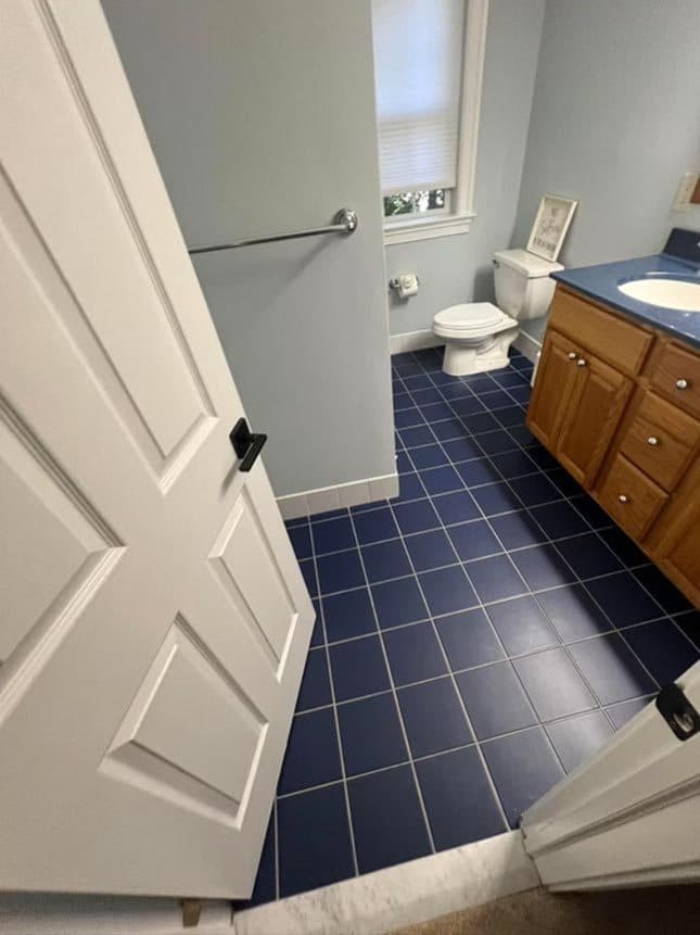 A dated bathroom before renovation with an oak vanity and a tub alcove