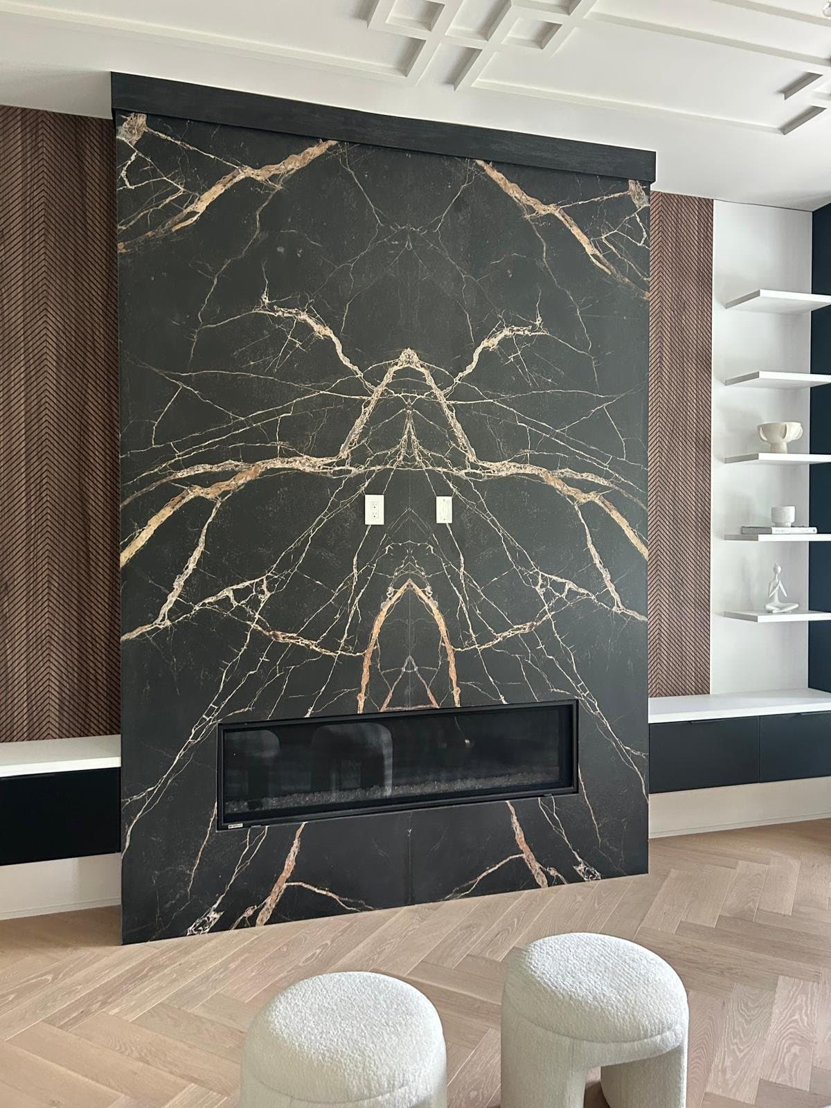 Book-matched black marble fireplace flanked by walnut